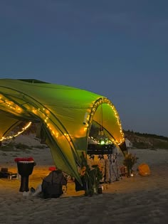 a tent with lights on it sitting in the sand