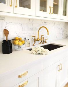 a kitchen with marble counter tops and gold faucets on the sink's side