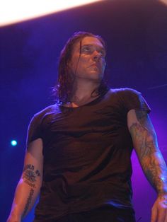 a man with long hair standing on stage