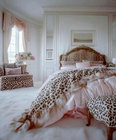 a leopard print bed spread in a white bedroom with pink pillows and chaires on the floor