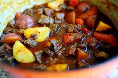 a bowl filled with stew and potatoes on top of a table