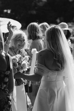 black and white photograph of two brides walking down the aisle