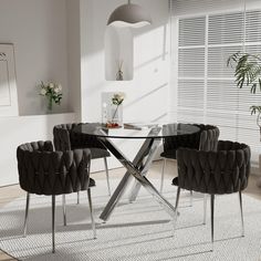 a glass dining table with four chairs around it