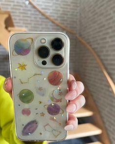 a person holding up a phone case with many different things on it in their hands