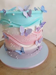 there is a multi layer cake with butterflies on the frosting and icing layers