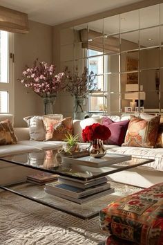 a living room filled with lots of furniture and flowers on top of a coffee table