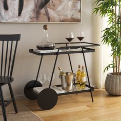 a bar cart with wine glasses and bottles on it