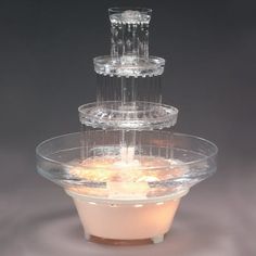 three tiered cake stand with lit candles in it and frosting on the bottom