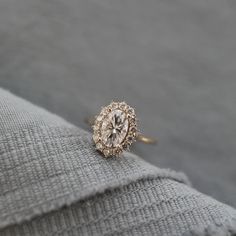 a diamond ring sitting on top of a gray sweater