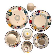 an assortment of dinnerware with circles and dots on the plates, cups and saucers