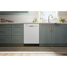 a dishwasher is in the middle of a kitchen with gray cabinets and gold handles