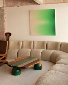 a living room filled with furniture and a painting on the wall