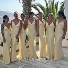 a group of women standing next to each other wearing yellow dresses and headbands