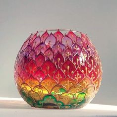 a colorful glass vase sitting on top of a table