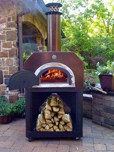 an outdoor pizza oven with logs in front of it