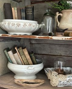 an old book shelf with books and bowls on it