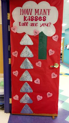 a door decorated with paper hearts and writing that says how many kisses are you?