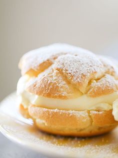 a pastry on a plate with powdered sugar and icing sitting on top of it