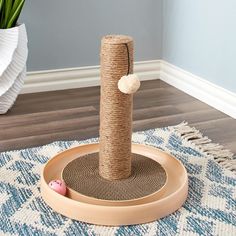 a cat scratching post on top of a rug