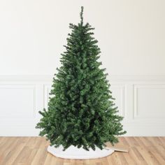 a small green christmas tree sitting on top of a wooden floor