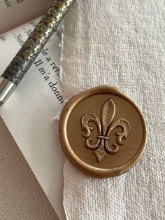 a wax stamp with a fleur de lis symbol on it sitting on top of a piece of paper