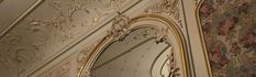 an ornately decorated wall and mirror in a room