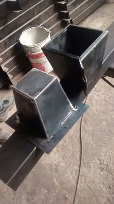 an empty bucket sitting on top of a metal bench