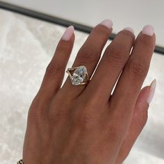 a woman's hand with a ring on it and a diamond in the middle