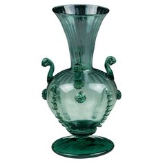 a green glass vase sitting on top of a table