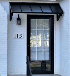 the front door of a white house with black trim