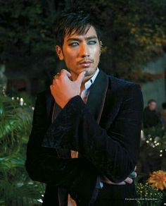 a man in a tuxedo is posing for a photo with his hand on his chin