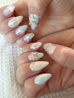 a woman's hands with some white and silver nail polishes on their nails