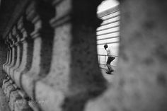 a man riding a skateboard down the side of a stone wall next to a window