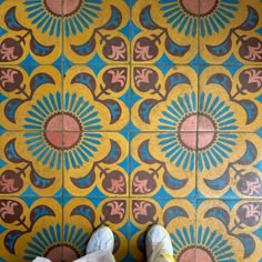 someone standing in front of a colorful tile floor