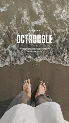 a man laying on top of a sandy beach next to the ocean with his feet in the sand