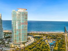 an aerial view of two high rise buildings next to the ocean