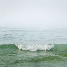 a person riding a surfboard on top of a wave in the ocean