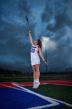 a woman jumping up into the air to hit a ball with her racquet