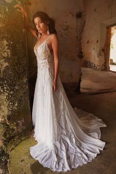 a woman in a wedding dress leaning against a wall