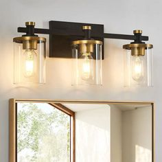 a bathroom vanity with three lights and a mirror