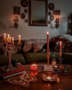 a living room filled with lots of candles on top of a wooden table next to a couch