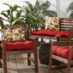 the patio furniture is set up with red pillows