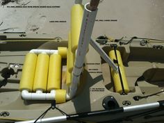 there are many yellow tubes attached to the front of a boat with two oars on it