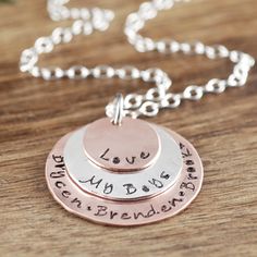 three discs with names on them sitting on top of a wooden table next to a chain