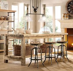 a kitchen island with three stools in front of it and a clock on the wall