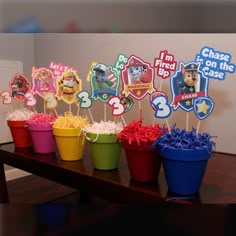 a table topped with cupcakes and cake toppers in front of a wall