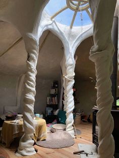 the interior of an unusual house with white walls and arches on the ceiling is covered in fabric