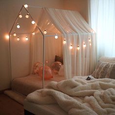 a bed with white sheets and lights on it