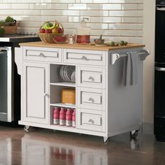 a white kitchen island with open shelves and drawers