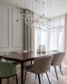 a dining room table with four chairs and a chandelier hanging from the ceiling